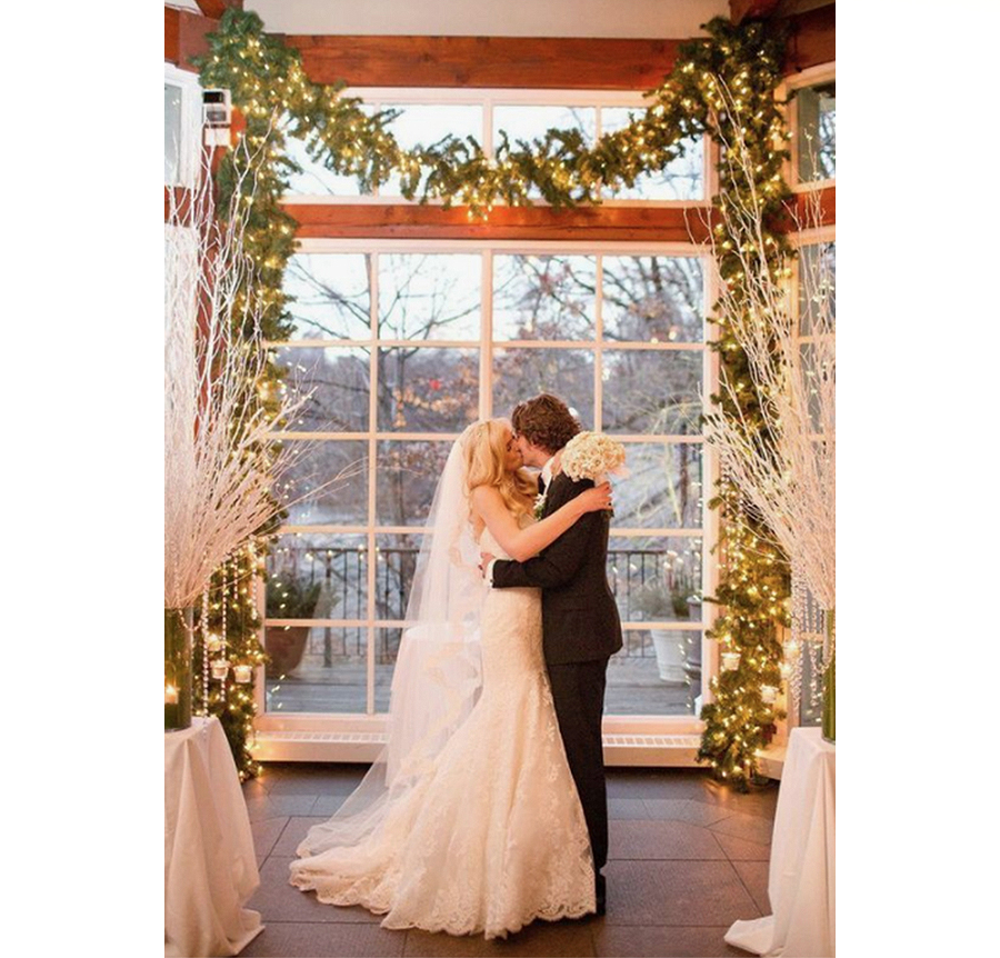 Wedding Vendors - Bride And Groom Kissing At A Christmas Wedding With Garlands